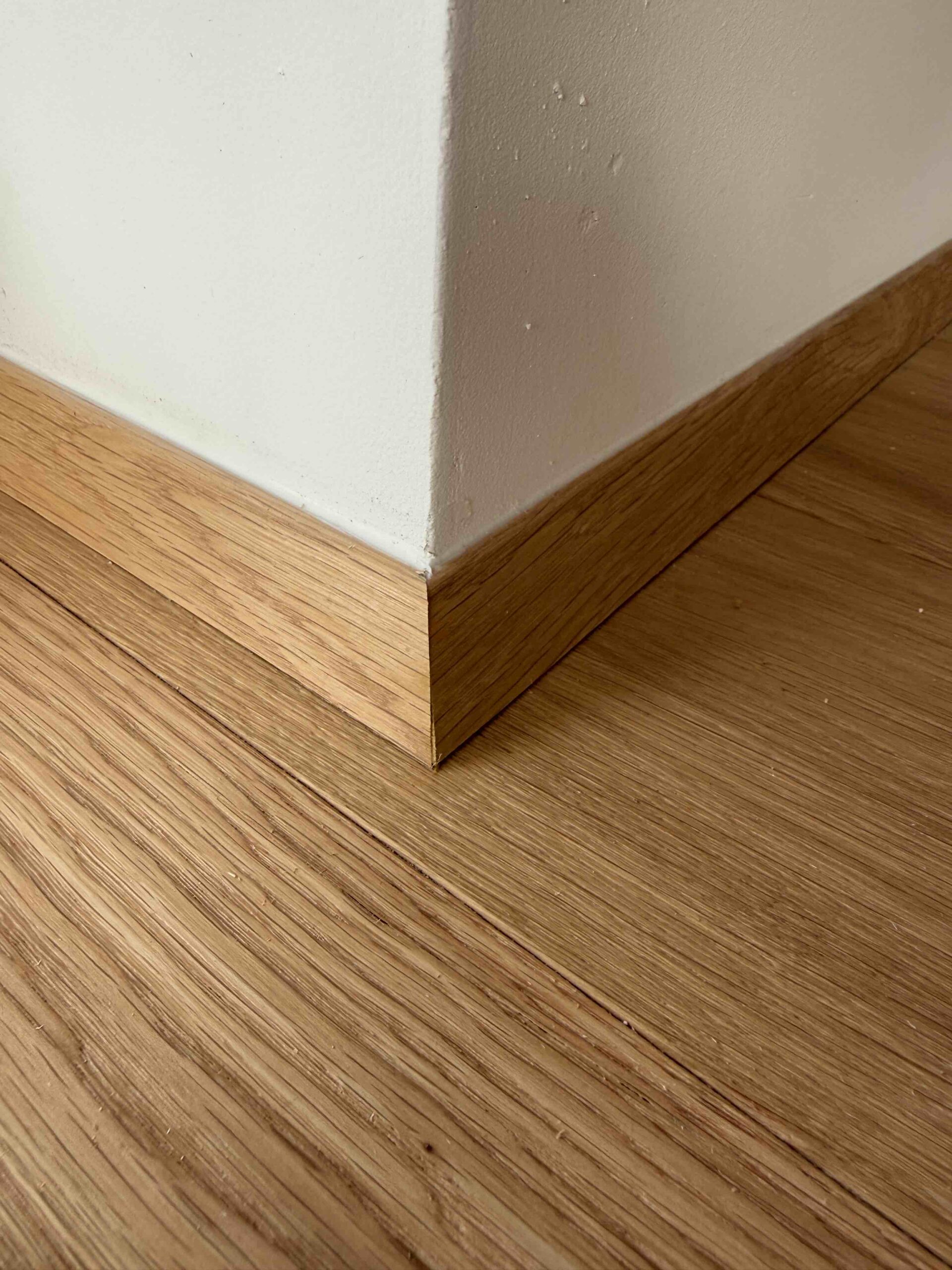 dřevěná dubová lišta okolo zdi dřevěná podlaha